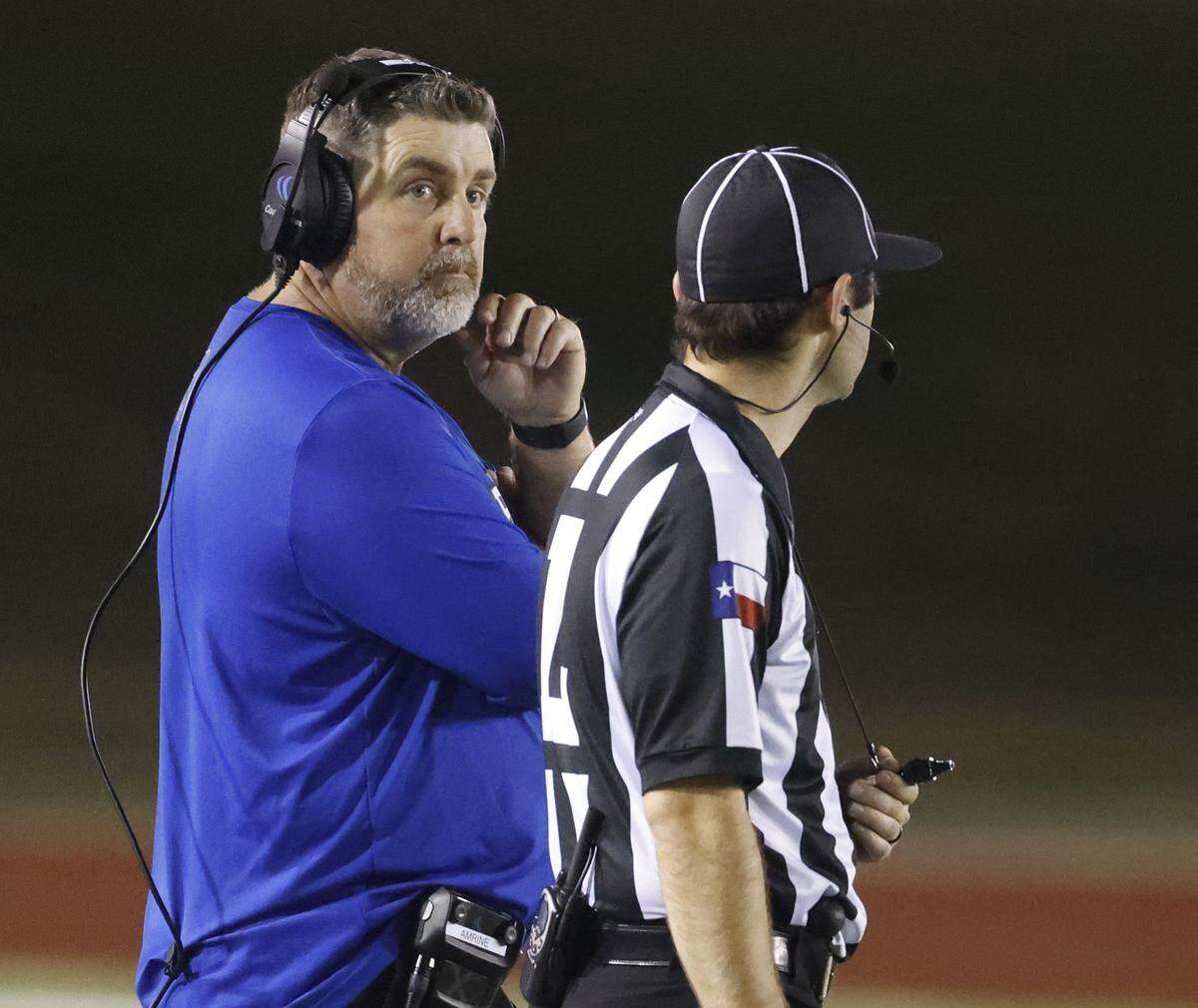 Brewer head coach Marte Amrine watches the play clock in anticipation of calling a timeout during the first half of a UIL Conference 5A D1 Bi-District playoff game between Arlington Heights and Brewer at Farrington Field in Fort Worth, Texas, Friday, Nov. 14, 2025.