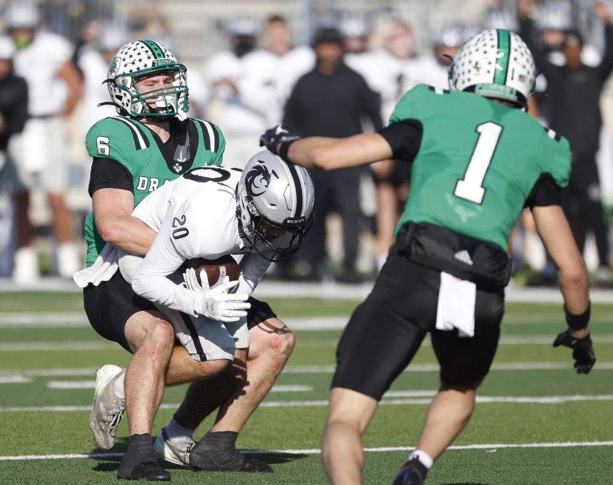 Southlake Carroll defensive back Parker Harris (6) wraps up Denton Guyer wide receiver Alex Warren (20) after a catch during the first half of a UIL Class 6A Division II Quarterfinal on Saturday Dec. 06, 2025 at Crowley ISD Multi-Purpose Stadium in Fort Worth, Texas.