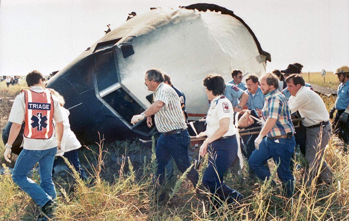 Aug. 31, 1988: Rescue workers carry the pilot of Delta 1141 to an ambulance. Most of the other survivors were able to walk away from the crash at Dallas-Fort Worth International Airport.