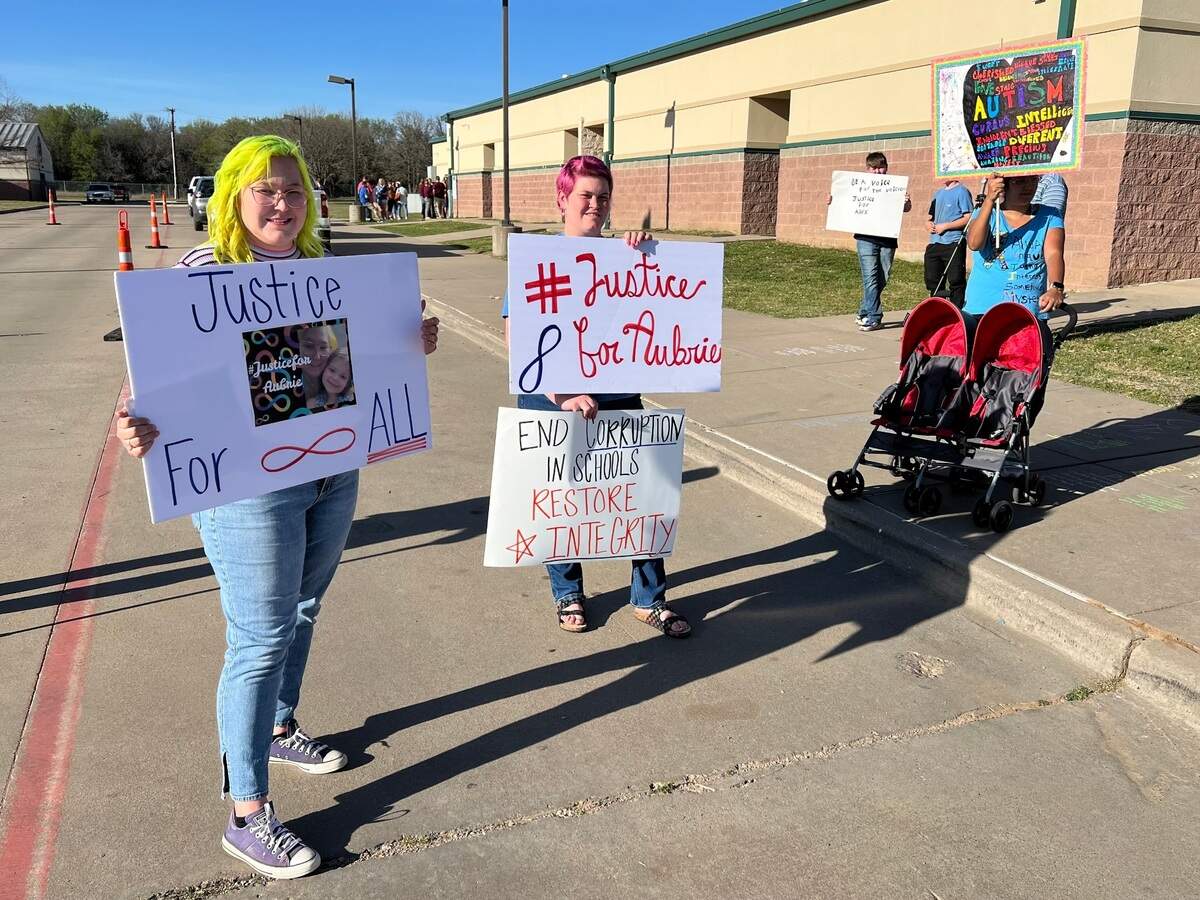 Millsap ISD parent Kinsie Davis, her daughter Aubrie’s godmother Elizabeth Counts and Mineral Wells resident Angela Pare stand left to right on Monday, March 24, with signs calling attention to autism awareness and justice for Millsap students in the special education program who were allegedly subjected to abuse by educators.