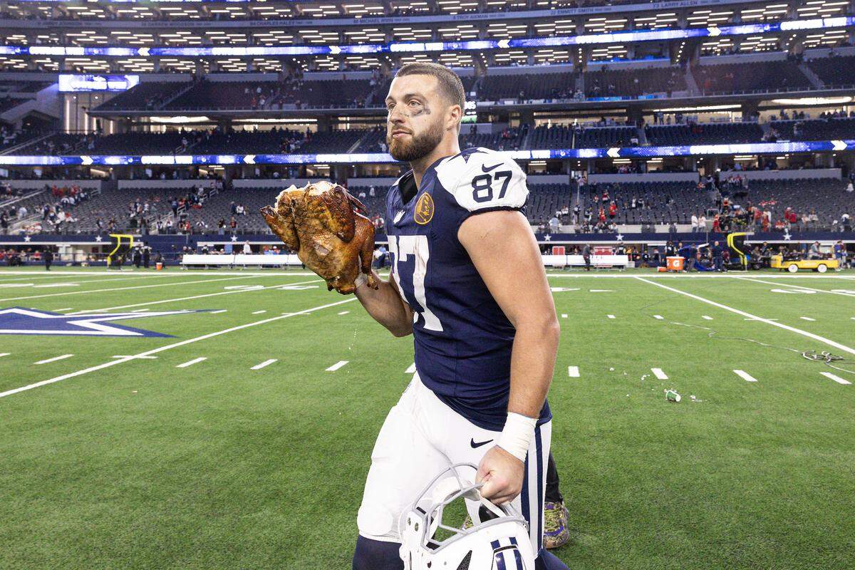 Dallas Cowboys tight end Jake Ferguson runs into the locker room with the turkey on his hand after winning an NFL game between the Cowboys and the Kansas City Chiefs at AT&T Stadium in Arlington on Thursday, Nov. 27, 2025. Dallas won 31-28.