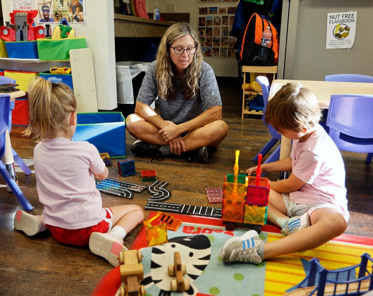 Cross Timbers Forest Preschool teacher Andrea Smith watches Evelyn and William play with magnetic building blocks at the school at the Bob Jones Nature Center and Preserve in Southlake on Friday, Sept. 22, 2023. Children get standard classroom education along with learning on trails and in the forest.