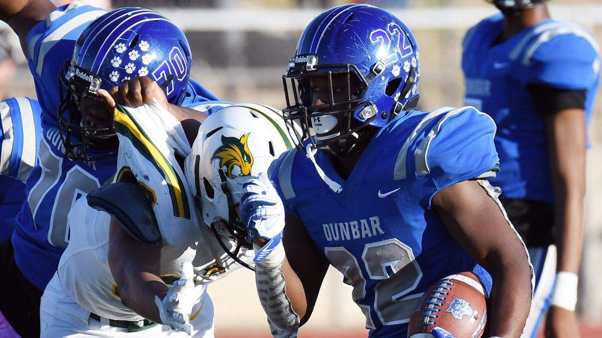 Dunbar’s Savyon Barrett races through the Benbrook line in the fourth quarter during Saturday’s football game at Clark Stadium in Fort Worth, Texas.