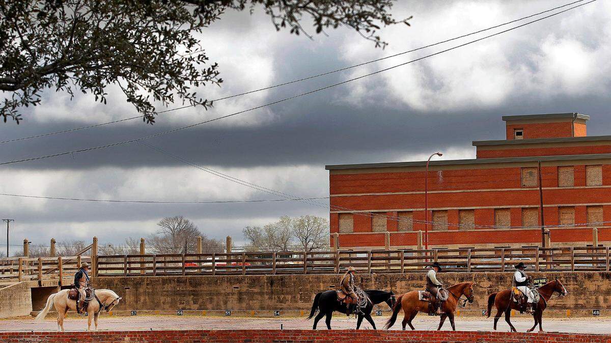 Cowboys ride after escorting longhorns in the Fort Worth Stockyards on March 27, 2014, with the historic Armour building in the background. Back then, some were skeptical of the proposal to redevelop Mule Alley.