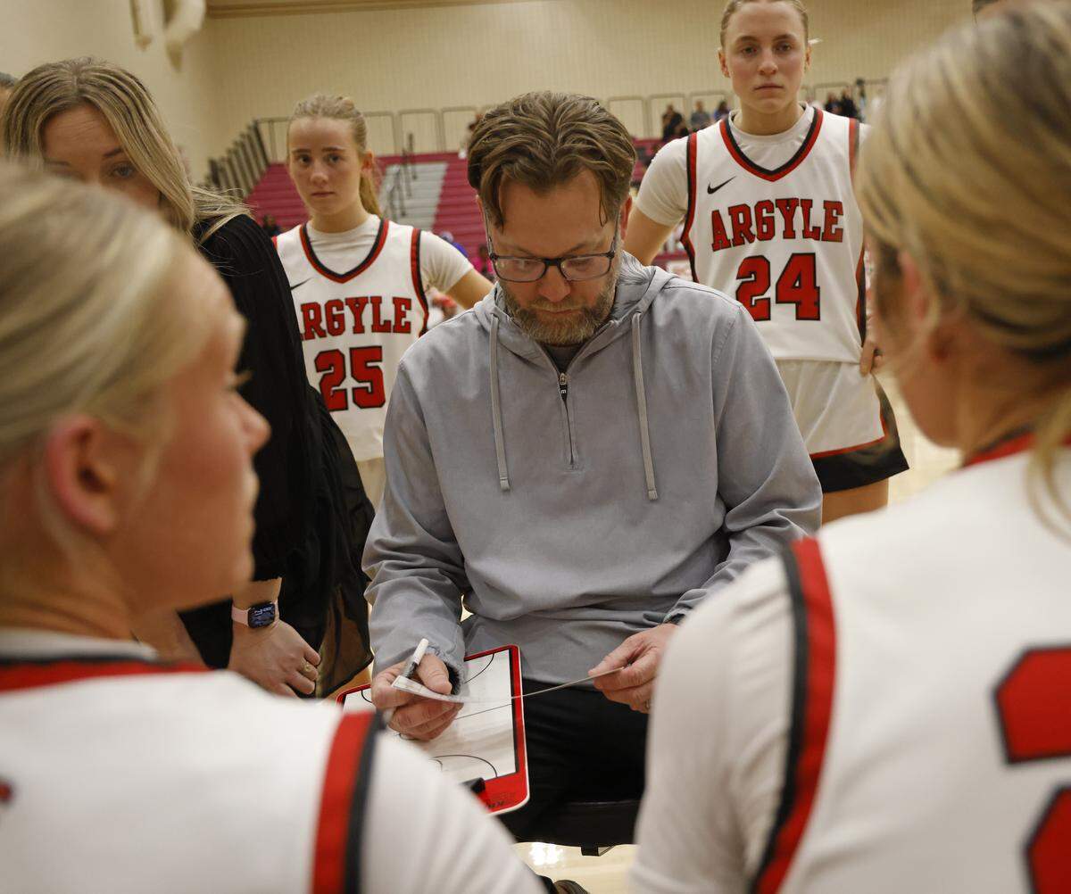 Argyle head coach Chance Westmoreland checks his notes while talking to the team during a timeout against Mansfield in the second half of a UIL Class 5A DII girls playoff basketball game at Saginaw High School in Saginaw, Texas, Thursday Feb. 19, 2026.