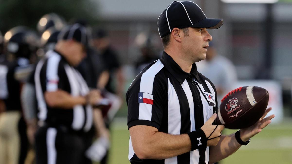 The backfield judge takes the ball on to the field in the first half of an UIL football game at Keller ISD Stadium in Keller, Texas, Thursday Aug. 31, 2023.