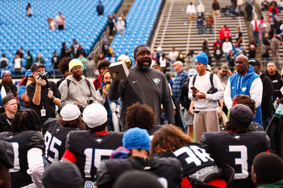 North Crowley head coach Ray Gates holds the trophy while speaking to his team following a 46-21 win over Coppell in a Class 6A Division I regional playoff Saturday at Midlothian ISD Stadium in Midlothian.