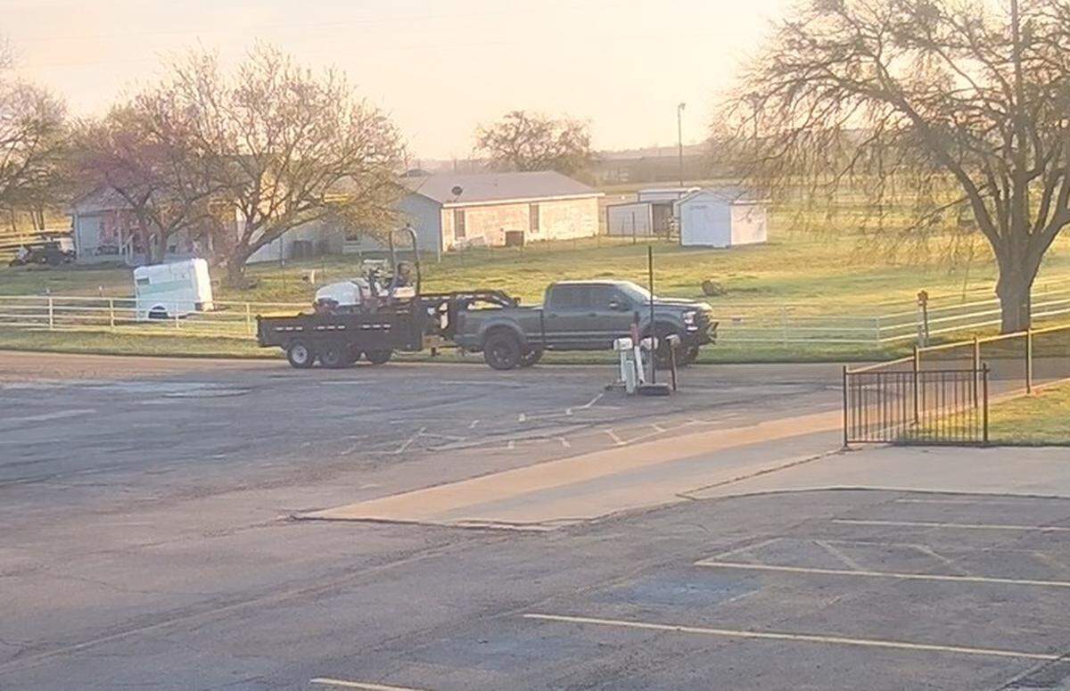 The Rhome Police Department is looking for a suspect driver and vehicle wanted for forcing a motorcyclist off the road on Friday, March 10, 2023, on U.S. 287 between Pioneer Parkway and State Highway 114. The vehicle is described as a gray Ford four-door truck, either an F250 or F350 model, hauling a black gooseneck trailer. The trailer has mismatched tires and had a black asphalt roller, or similar equipment, with a high bar behind the seat.