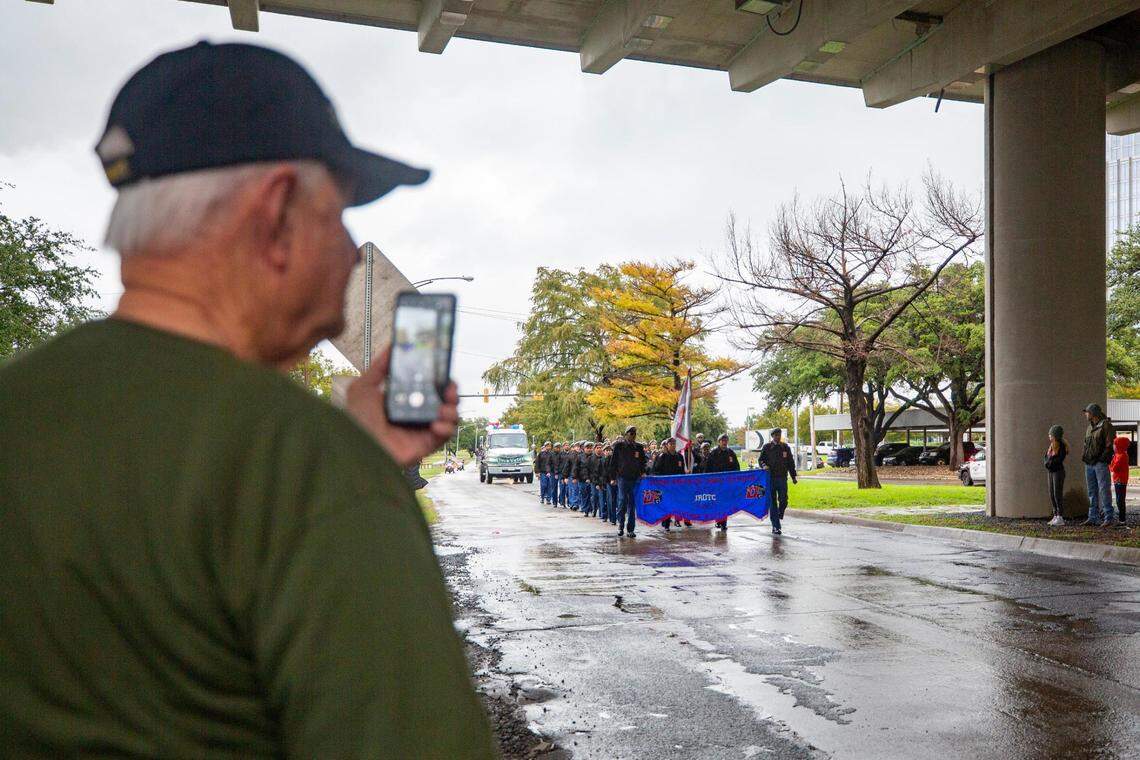 A veteran records the Veterans Day Parade as it approaches in Fort Worth on Friday, Nov. 11, 2022. Despite rain, hundreds of participants marched down North Forest Park Boulevard, waving American flags and signing a medley of military songs.