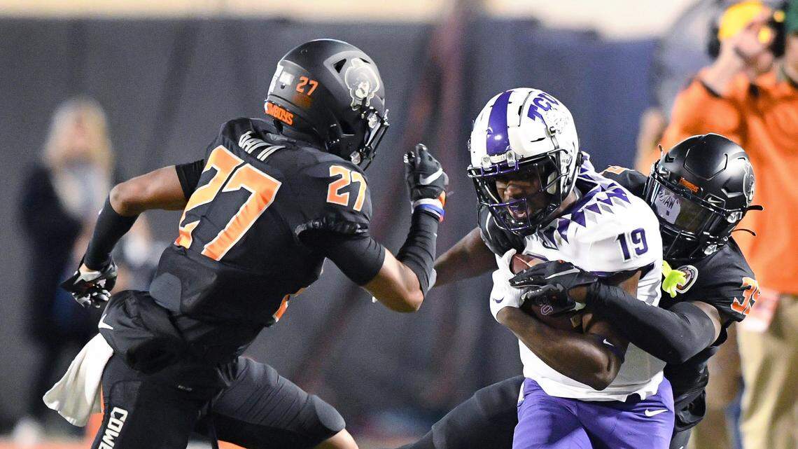 TCU receiver TJ Steele is dragged down by Oklahoma State safety Trey Rucker as cornerback Raymond Gay II (27) rushes to help in Saturday’s game in Stillwater. The Horned Frogs lost 63-17, their worst loss since 1993.