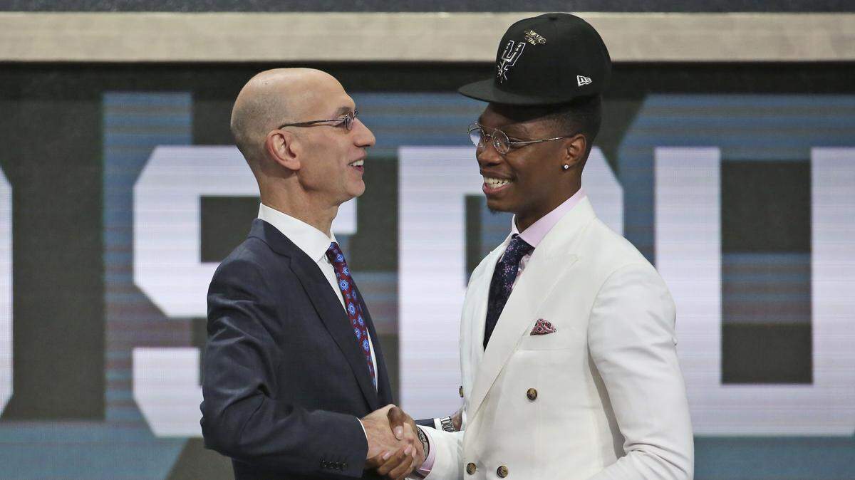 Miami's Lonnie Walker IV, right, shakes hands with NBA Commissioner Adam Silver after he was picked 18th overall by the San Antonio Spurs during the NBA basketball draft in New York, Thursday, June 21, 2018.