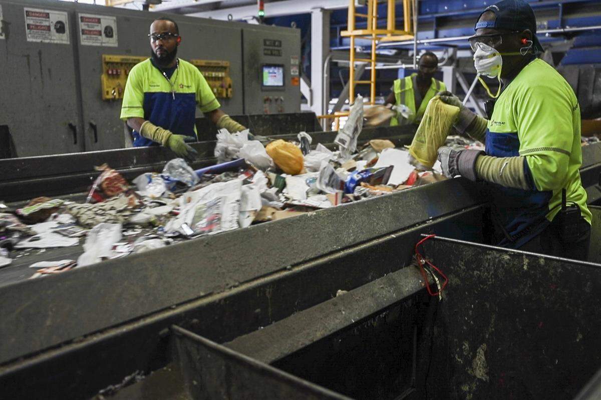 Workers sort items on conveyer belts Thursday, Aug. 29, 2019, at Republic Services sorting facility in Fort Worth.