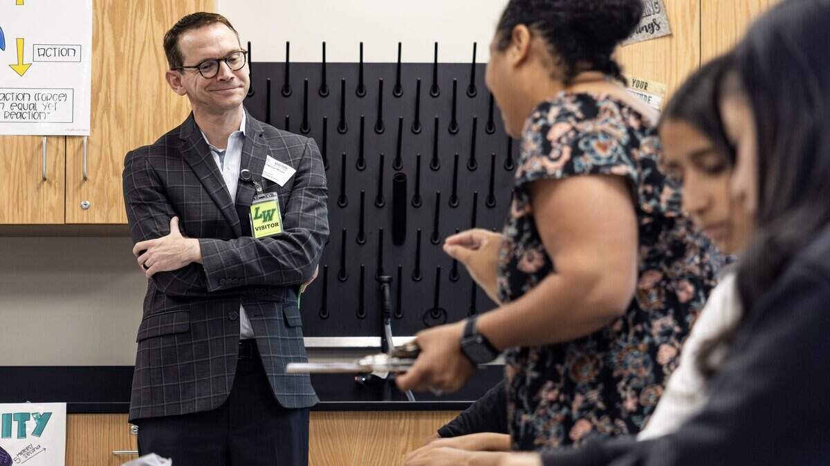 Mike Morath, the Texas Commissioner of Education, looks over the work of a student in a science class at Lucyle Collins Middle School in Lake Worth on Tuesday, Oct. 21, 2025. 