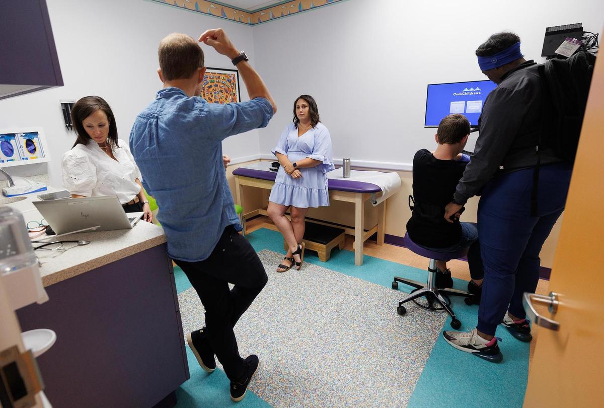 Neurosurgeon Dr. Daniel Hanson, second from left, explains a procedure to Meghan Czarobski, center, during an appointment for her son, Preston Benjaman-Sewell, seated right, at Cook Children’s Dodson Specialty Clinics in June. Czarobski said she usually has around five to seven appointments with Cook Children’s per month for Preston who has autism, an intellectual and developmental disability and a rare form of epilepsy called Lennox-Gastaut syndrome.