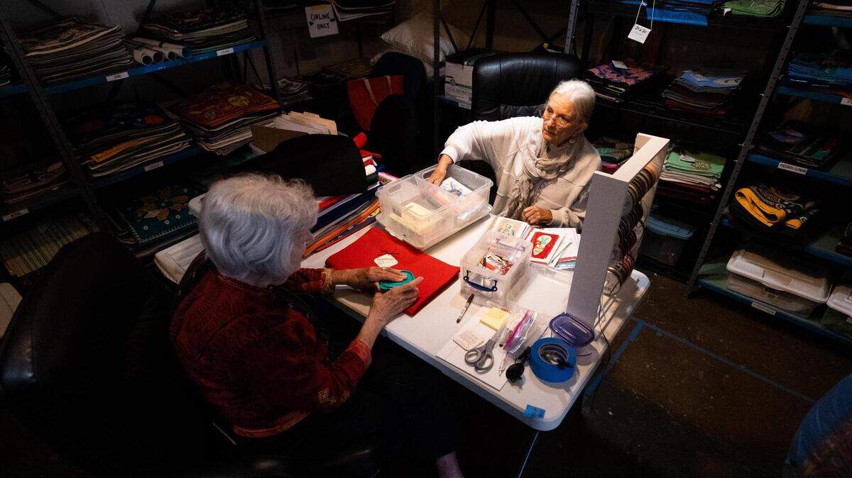 M’Lou Bancroft and Barbara Velhum sort through cards and embroidered cases for Honduras Threads on Wednesday in Dallas. Honduras Threads works with women in Honduras who create the products for customers in United States.