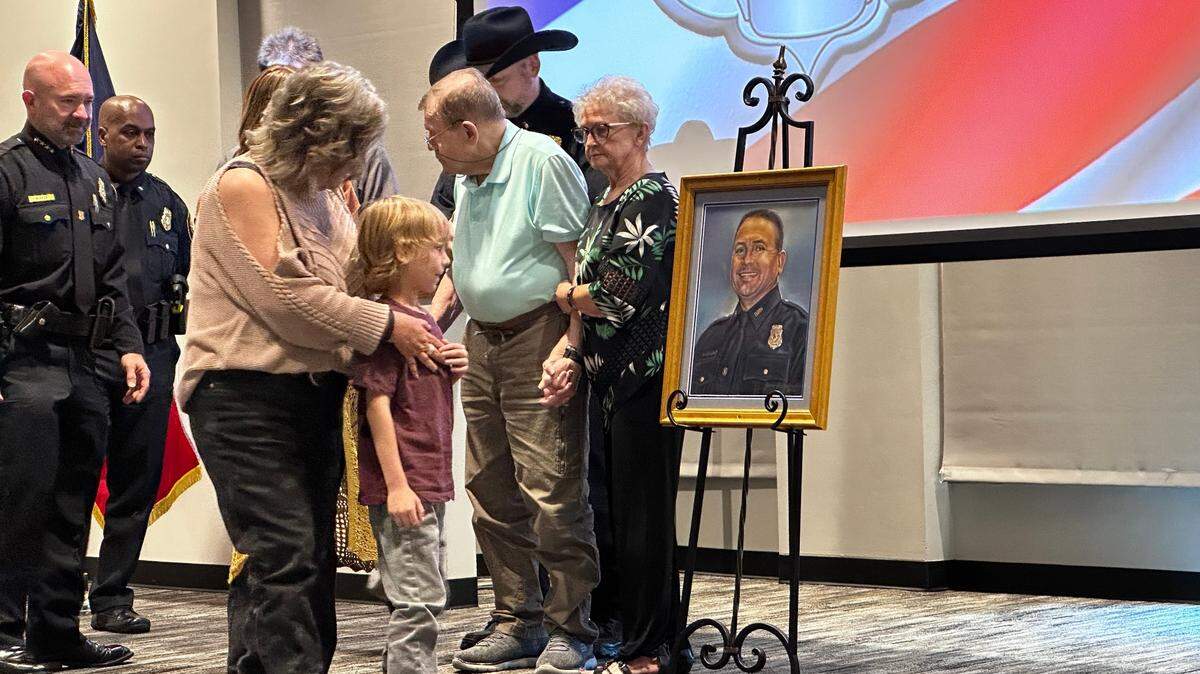 Family members look at Sgt. Billy Randolph’s portrait after it was unveiled Monday by the Fort Worth Police Department.