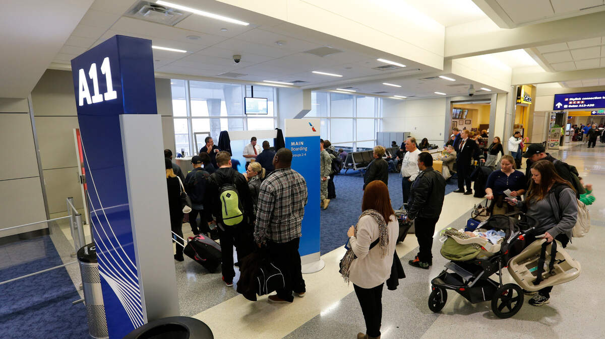 Passengers line up to board a plane at Terminal A in the Dallas/Fort Worth Airport on Jan. 8, 2014.