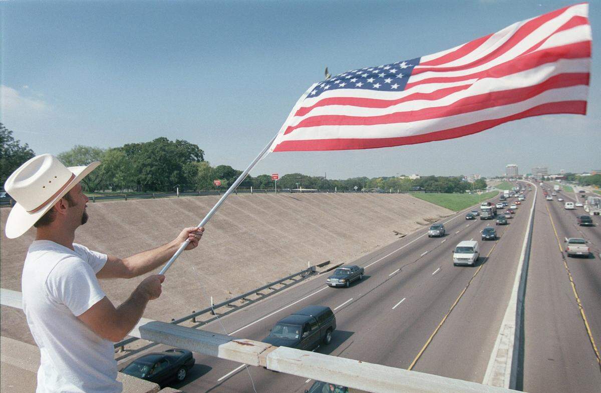 Russell Ward of Richland Hills waves a flag on Airport Freeway in Hurst on the morning of Sept. 11, 2001. Ward bought the flag that morning and said that he was going to wave it until he felt better. Hurst police arrived and asked the man to leave.