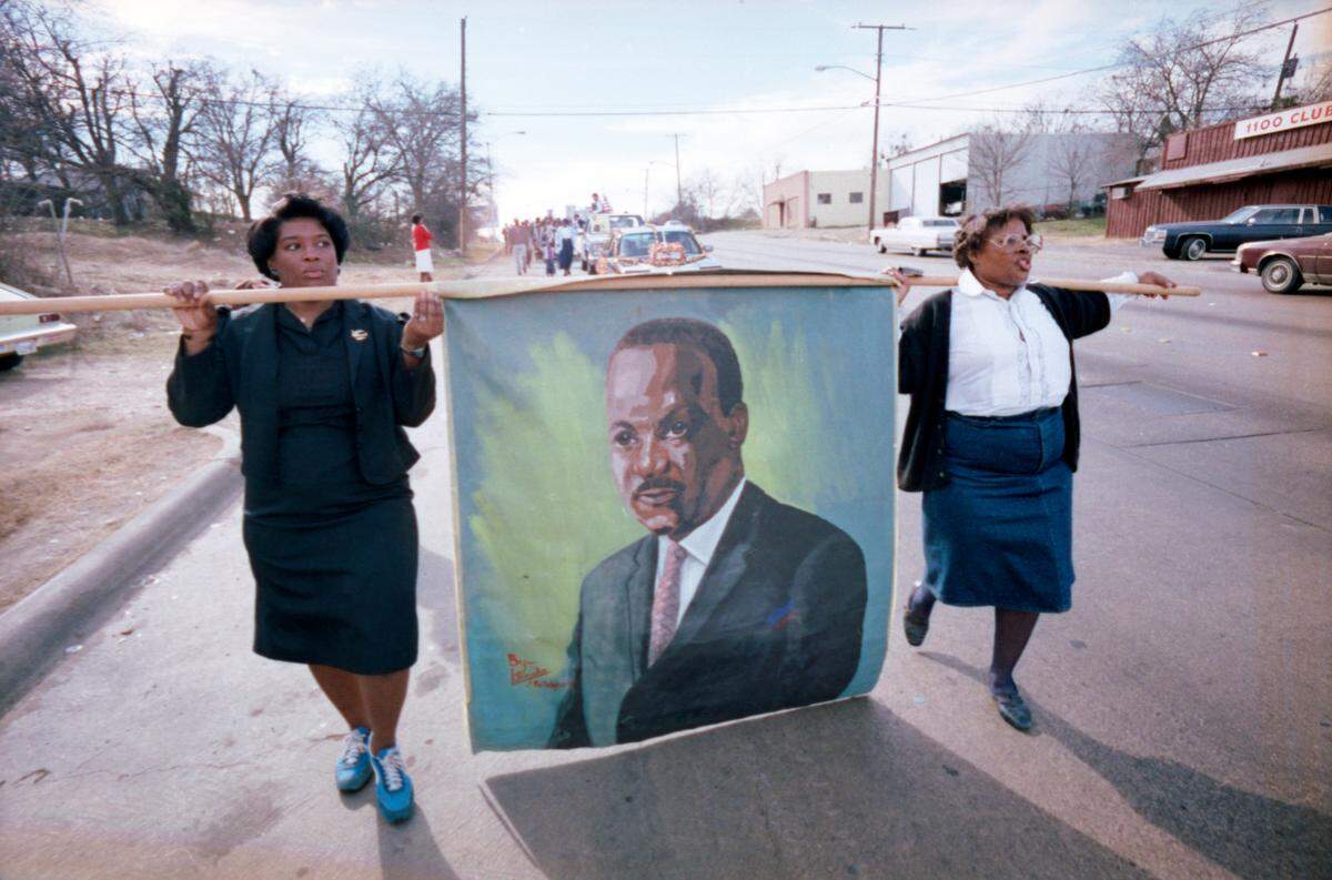 Jan. 15, 1986: Opal Lee, right, and Brenda Polk carry a painted banner of civil rights leader Martin Luther King Jr. during a memorial march along East Rosedale Street in Fort Worth