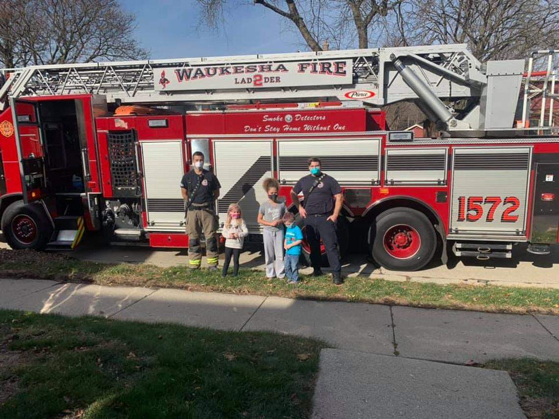 Parker and the gang posing with the fire fighters who rescued him from the cat tree