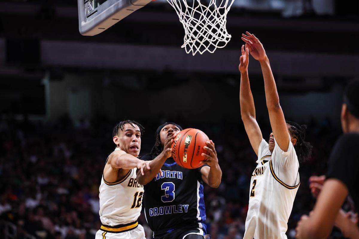 North Crowley guard Donte Grandberry (3) attempts to drive to the basket for a layup as two San Antonio Brennan defenders reach their hands up in the Class 6A Division I state championship at The Alamodome in San Antonio, Texas, March 14, 2026.