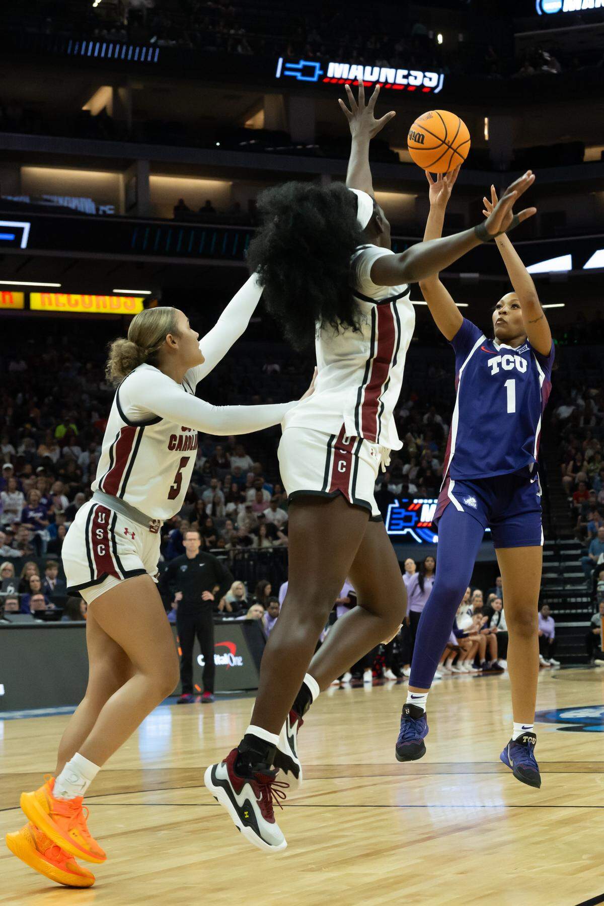 TCU guard Taylor Bigby (1) shoots against South Carolina center Madina Okot (11) and guard Tessa Johnson (5) in the Elite Eight of the NCAA Tournament on Monday at Golden 1 Center in Sacramento, Calif.