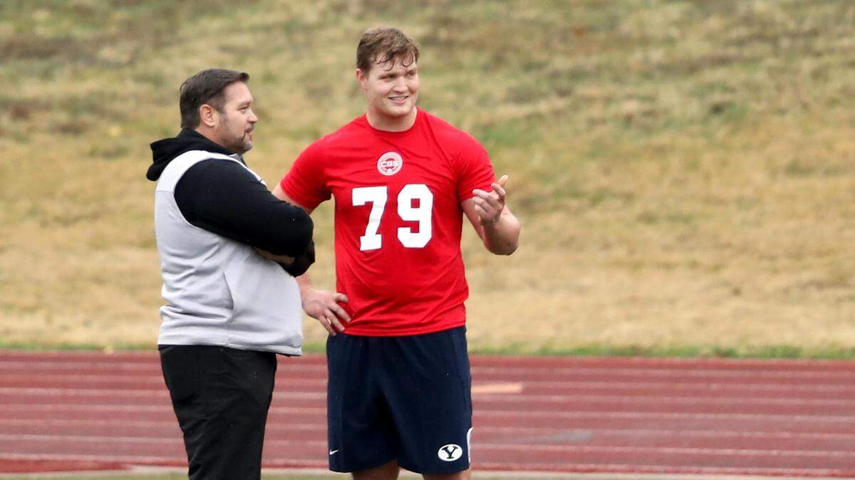 BYU’s Chandon Herring (79) talks with former Dallas Cowboys offensive lineman Mike Kiselak during the College Gridiron Showcase held at Farrington Field last week.