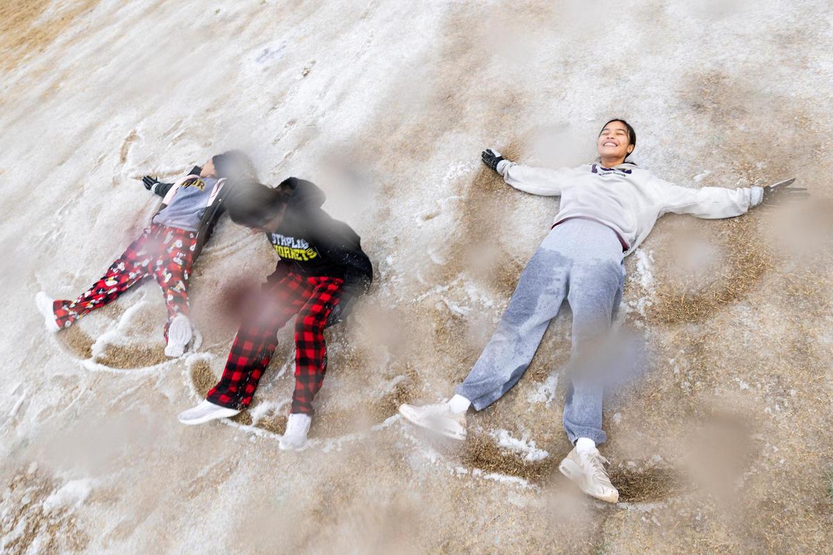 Stripling Middle School students Ariana White, 14, Isabella Rodriguez, 14, and Cecilia Rico, 14, make snow angels in their neighborhood park in Southwest Fort Worth on Thursday, Jan. 9, 2025. The winter storm led to all Fort Worth ISD schools to close for the rest of the week.