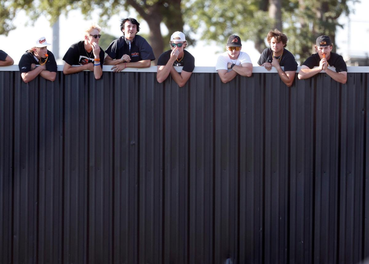 Softball fans look over the right field fence during the UIL softball state semifinals 5A D1 playoff game at Trojan Softball Field in Euless, Texas, Wednesday, May 21, 2025.