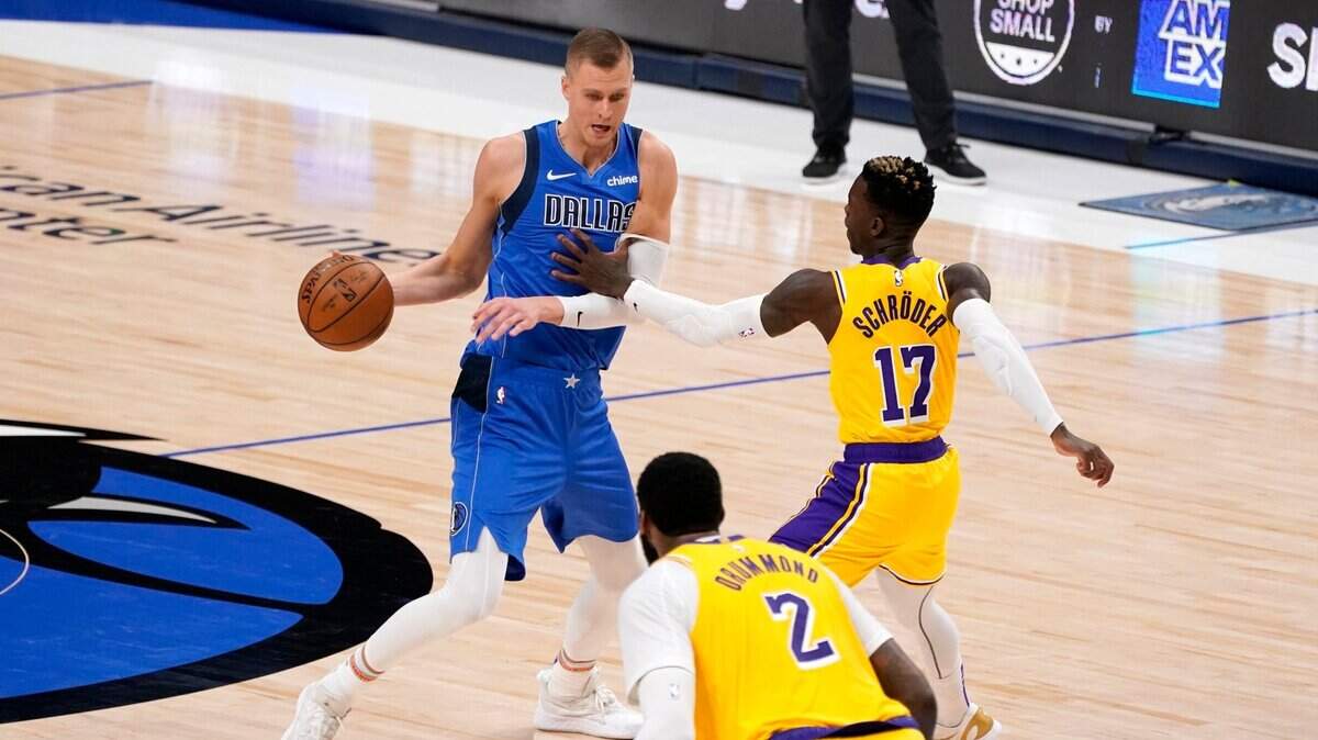 Dallas Mavericks’ Kristaps Porzingis works to get to the basket as Los Angeles Lakers’ Andre Drummond (2) and Dennis Schroder (17) defend during Thursday’s game. (AP Photo/Tony Gutierrez)
