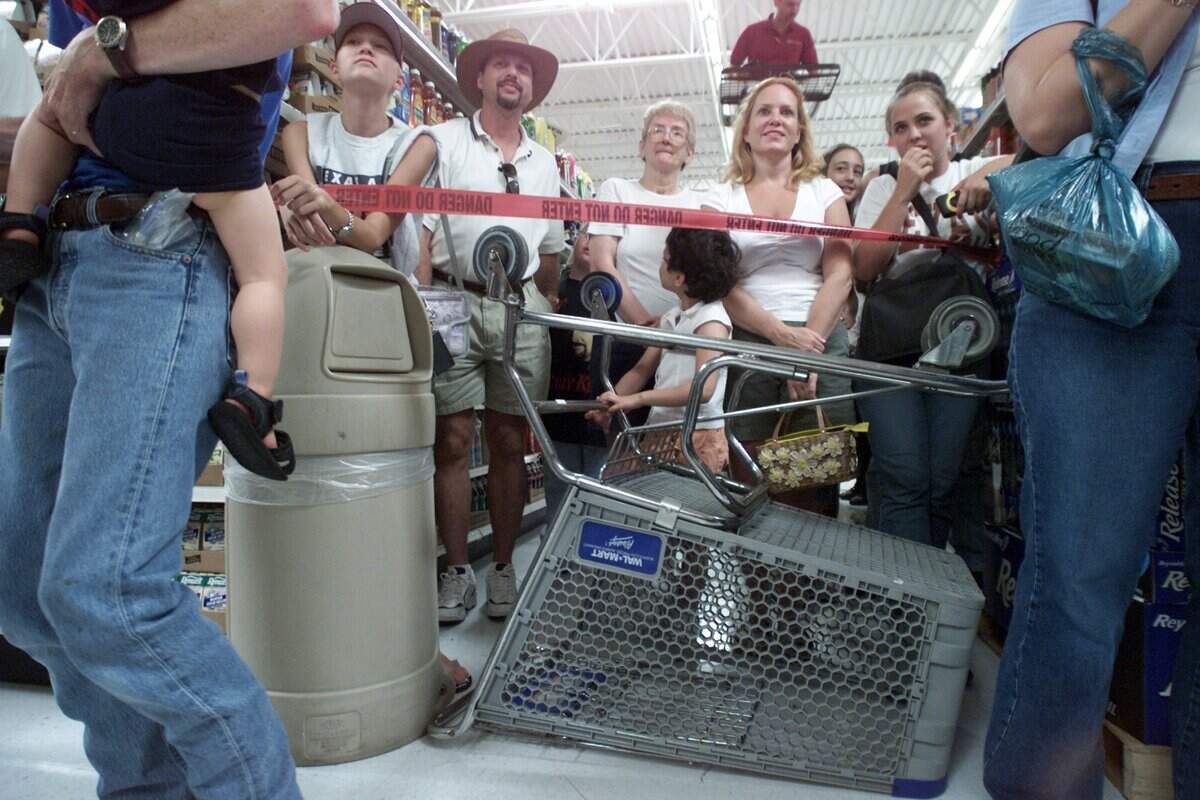People who were just at Wal-Mart in North Richland Hills to shop watched curiously at the spectacle from behind make-shift blockades as fans jammed the store to see country singer Toby Keith on July 28, 2002.