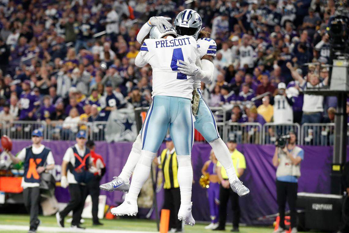Dallas Cowboys running back Ezekiel Elliott celebrates with teammate quarterback Dak Prescott (4) after scoring on a 1-yard touchdown run during the second half of an NFL football game, Sunday, Nov. 20, 2022, in Minneapolis. (AP Photo/Bruce Kluckhohn)