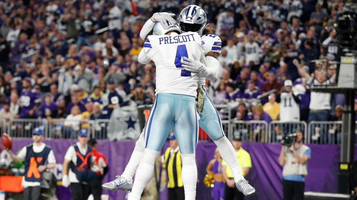 Dallas Cowboys running back Ezekiel Elliott celebrates with teammate quarterback Dak Prescott (4) after scoring on a 1-yard touchdown run during the second half of an NFL football game, Sunday, Nov. 20, 2022, in Minneapolis. (AP Photo/Bruce Kluckhohn)