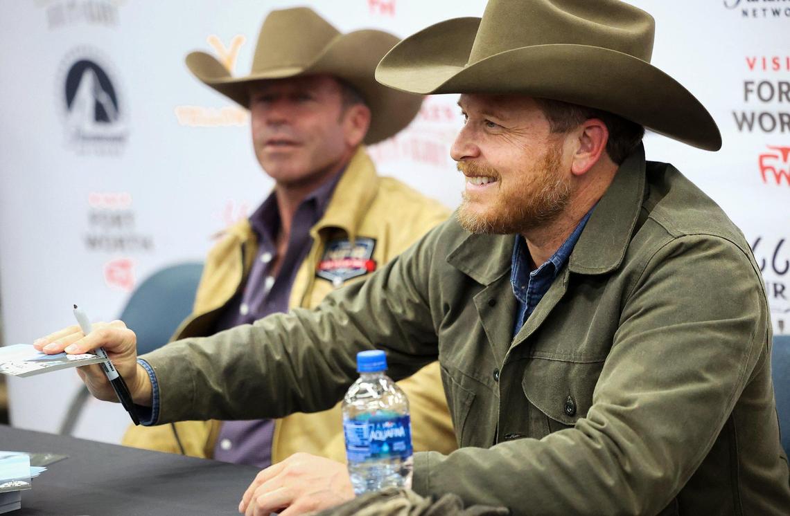 “Yellowstone” actor Cole Hauser (right) and show creator Taylor Sheridan sign autographs for fans at the Fort Worth Stock Show & Rodeo on Friday, February 3, 2023.