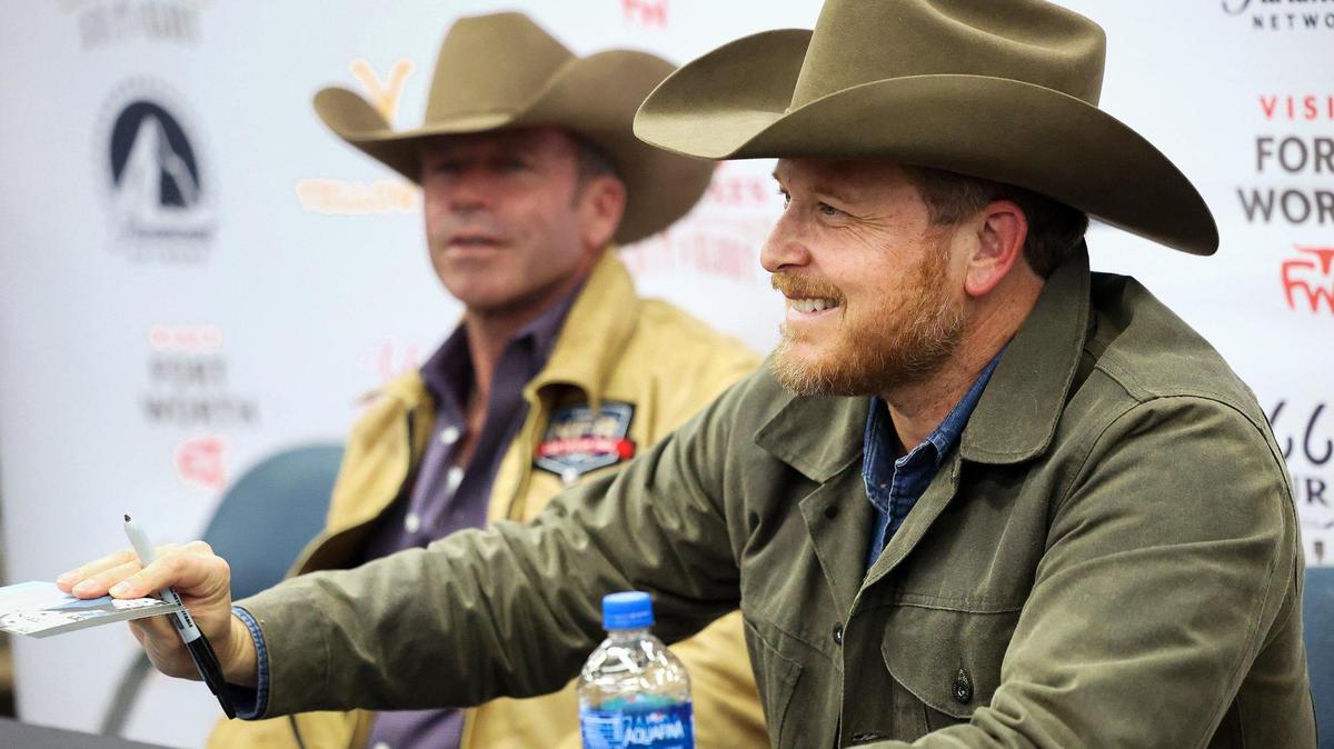 “Yellowstone” actor Cole Hauser (right) and show creator Taylor Sheridan sign autographs for fans at the Fort Worth Stock Show & Rodeo on Friday, February 3, 2023.
