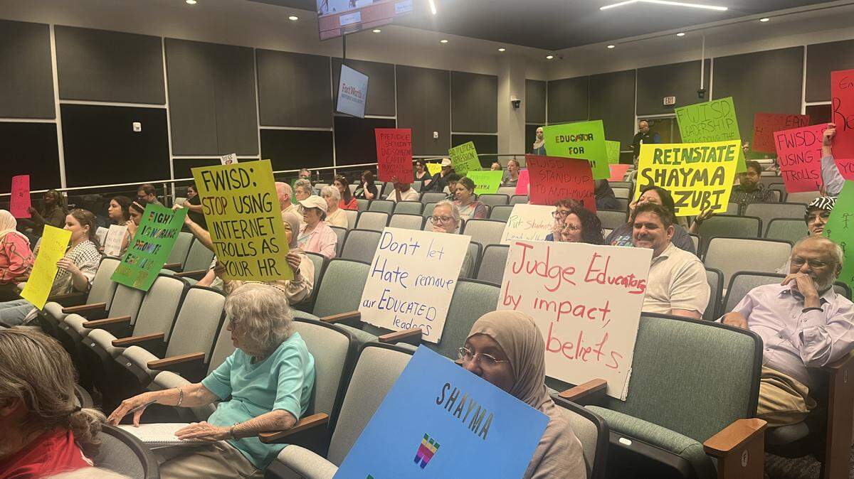 Supporters of Shayma Alzubi hold signs during a Fort Worth school board meeting on Monday, June 1, 2022. Alzubi was appointed as principal of Western Hills High School in May and reassigned days later after old social media posts of hers surfaced.