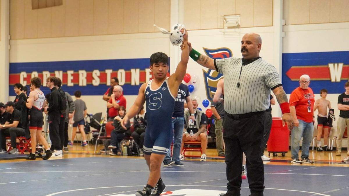 Kody Tanimoto gets his hand raised after a victory during the 2023-2024 high school wrestling season.