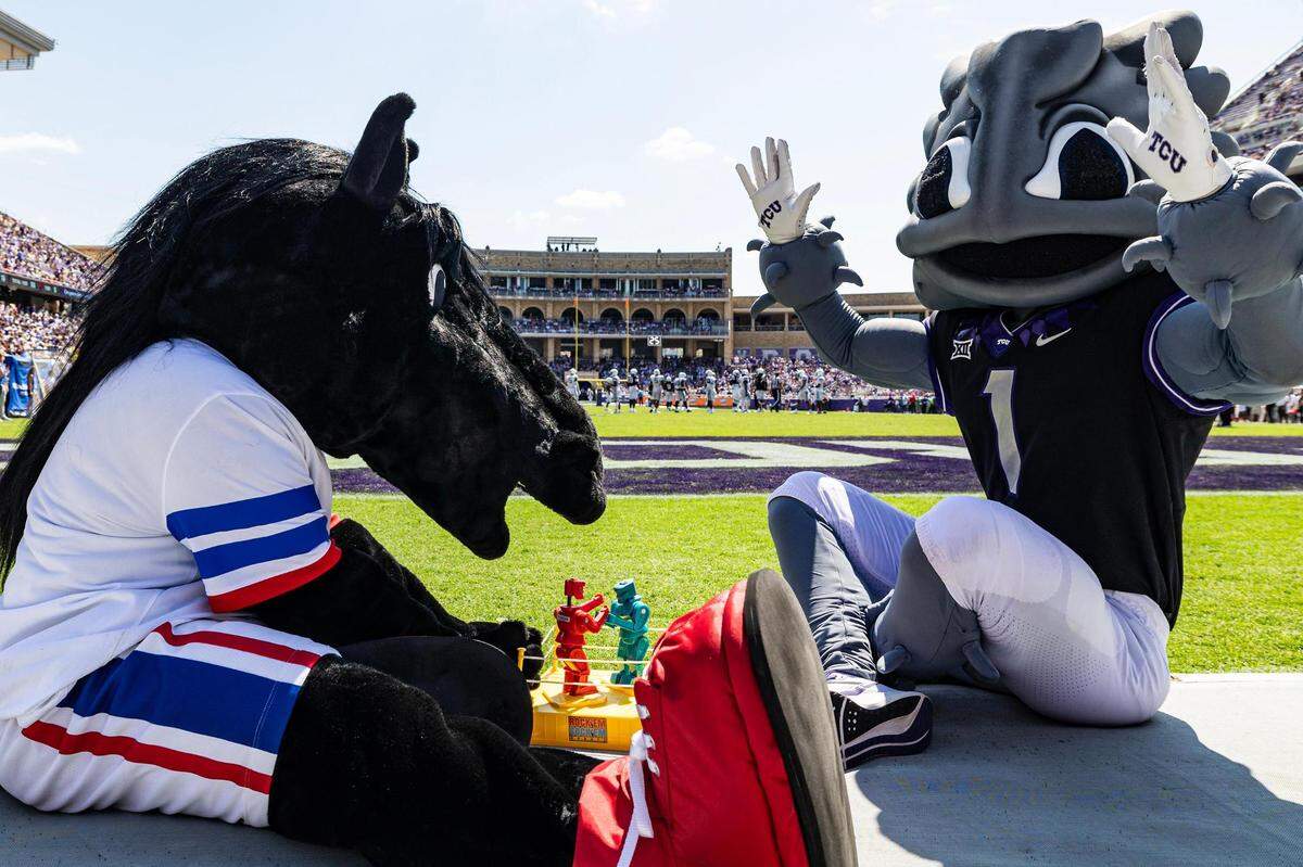 The SMU Mustangs mascot Peruna plays the TCU Horned Frogs mascot Super Frog in a game of rock-em-sock-em robots during a college football game between the TCU Horned Frogs and the SMU Mustangs at Amon G. Carter Stadium in Fort Worth on Saturday, Sept. 23, 2023.