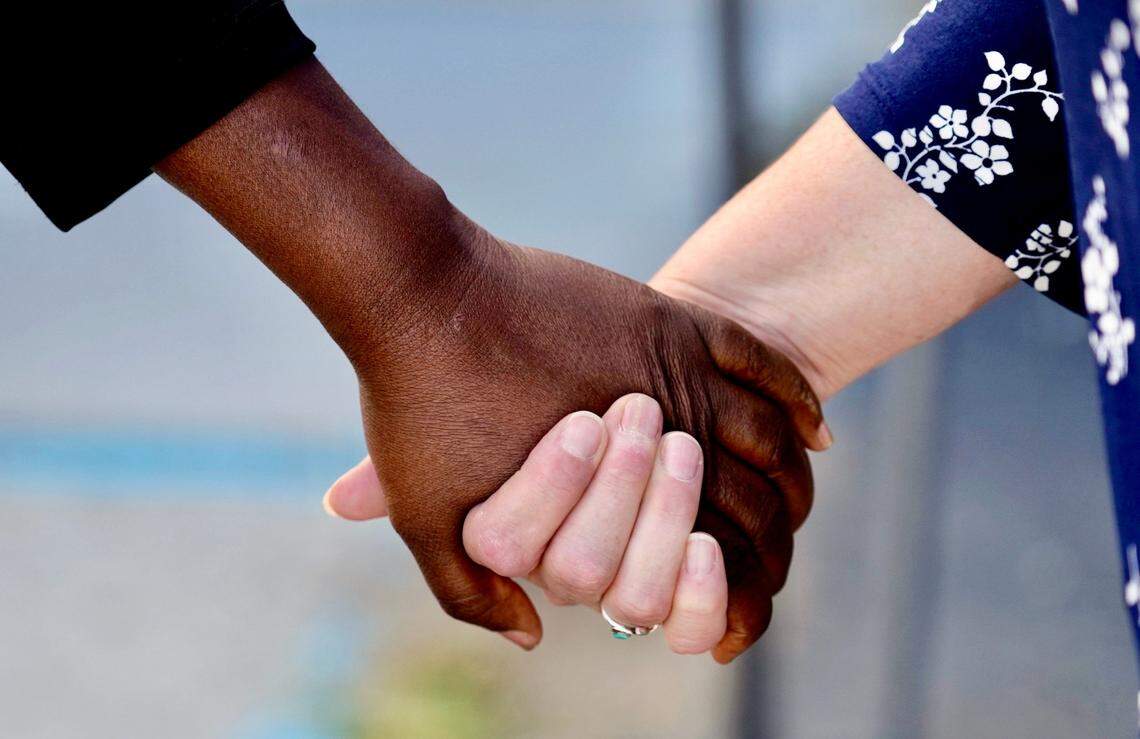 Heidi Earlywine, right, holds hands with Myriam Joseph outside the First Haitian Evangelical Church in Springfield, Ohio, Sunday, Sept. 15, 2024. The Haitian church as received threats since the area attracted national scrutiny after conservative figures, including former President Donald Trump and his running mate Sen. JD Vance, spread debunked claims that Haitians in the community were stealing and eating people’s pets.