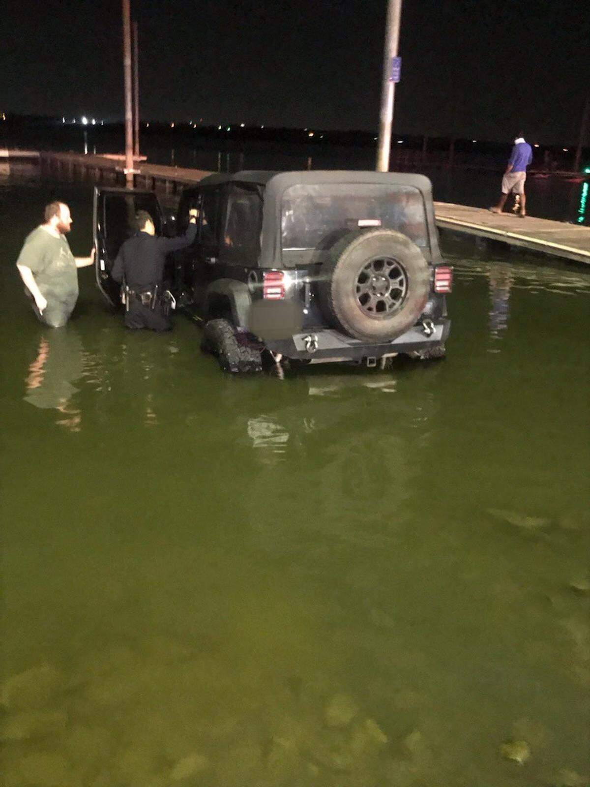 Arlington police inspect a Jeep submerged in Lake Arlington on Thursday night after a woman drove it into the water. She was arrested on a charge of DWI.