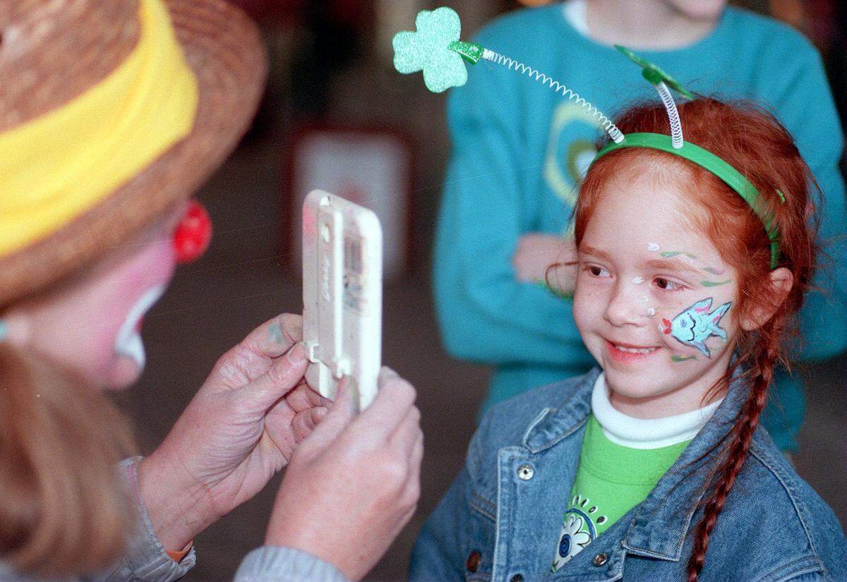 March 17, 2001: Carlie Scott, 4, admires the artistry of Winky the Clown (Ilene Rowland) after getting her face painted at the St. Patrick’s Day festivities at the Fort Worth Stockyards