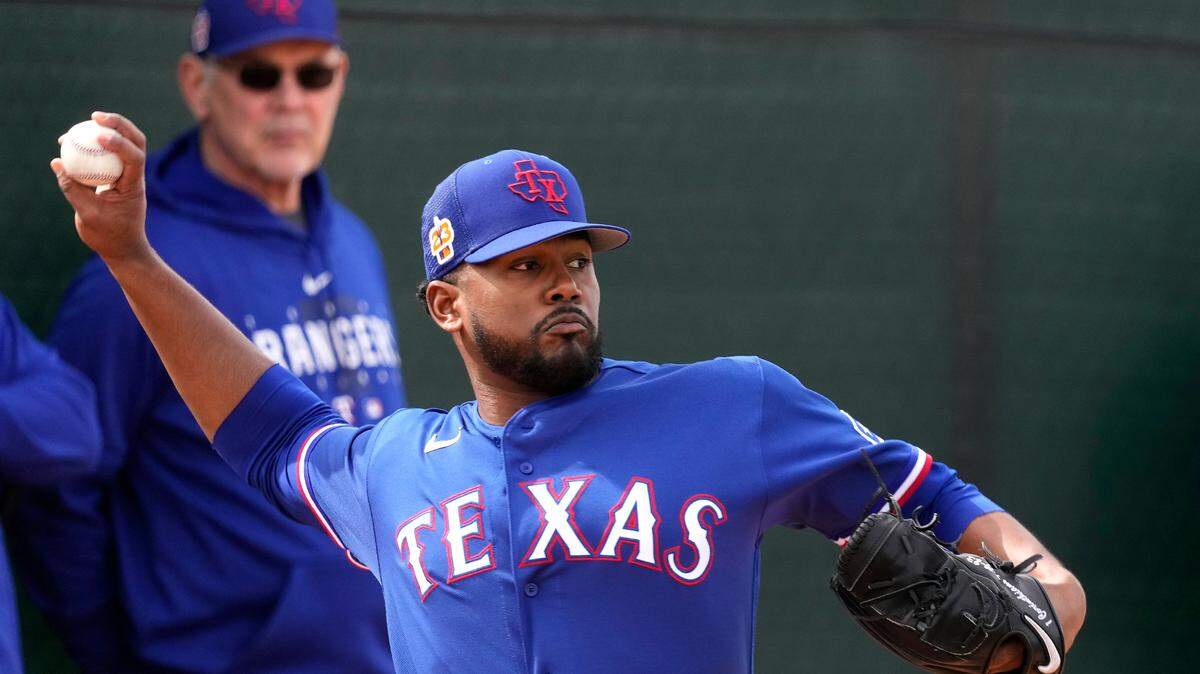 Texas Rangers manager Bruce Bochy watches while pitcher Kumar Rocker throws during spring training baseball practice.