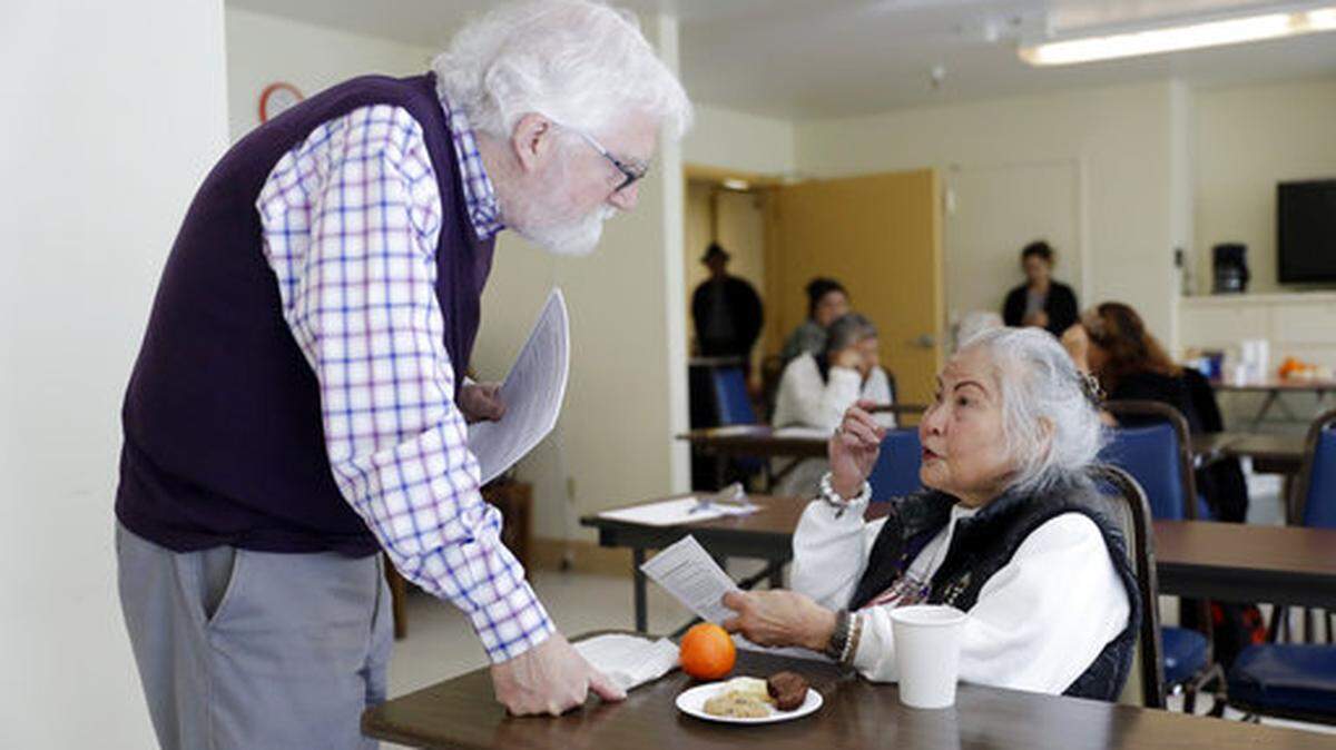 In this Friday, April 13, 2018 photo, Patrick Arbore, left, talks to Corazon Leano as he conducts an anti-bullying class at the On Lok 30th Street Senior Center in San Francisco.
