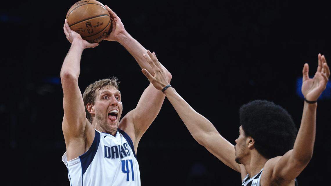 The Mavericks' Dirk Nowitzki looks for somewhere to pass while drawing the attention of Brooklyn defender Jarrett Allen.