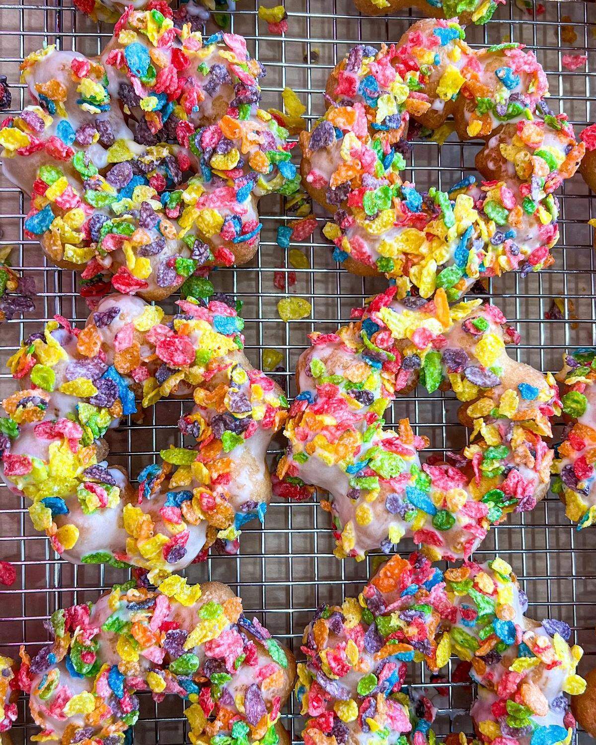 Glazed mochi donuts topped with Fruity Pebbles cereal at Devil & Angel.
