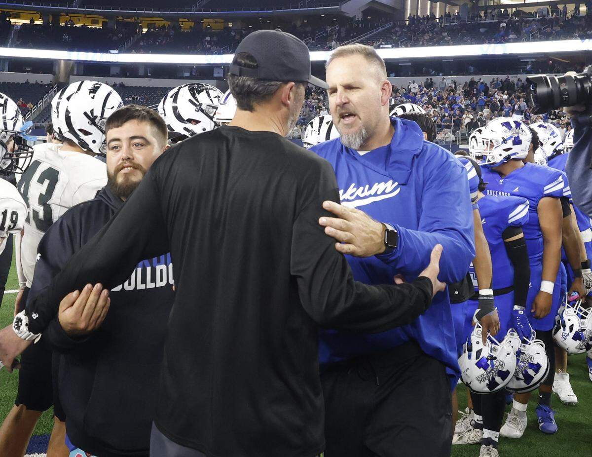 Yoakum head coach Bo Robinson and Grandview head coach Ryan Ebner exchange pleasantries at mid field after Yoakum defeated Grandview in the UIL Class 3A Division I championship game on Thursday Dec. 18, 2025 at AT&T Stadium in Arlington, Texas.