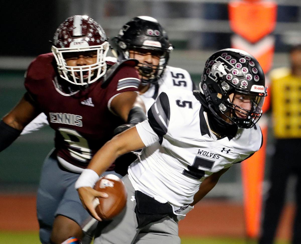Timberview quarterback Jaeden Marshall (5) avoids the tackle in the backfield by Ennis defensive lineman Lazarus Becks (9) in a class 5A Division 2 area round football playoff game at Lumpkins Stadium in Waxahachie, Texas, Friday Nov. 19, 2021. Timberview led 21-14 at the half.(Special to the Star-Telegram Bob Booth)