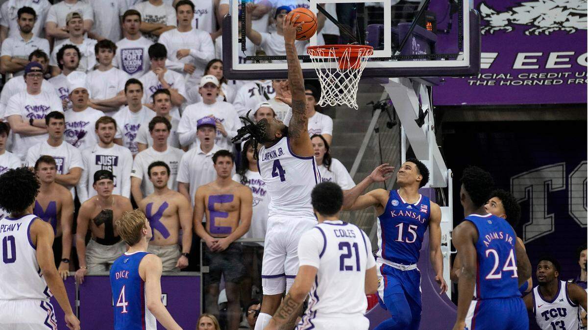 TCU center Eddie Lampkin Jr. (4) dunks over Kansas’ Kevin McCullar Jr. (15) as Kansas’ K.J. Adams Jr. (24) and TCU’s JaKobe Coles (21) watch during their game on Monday night.