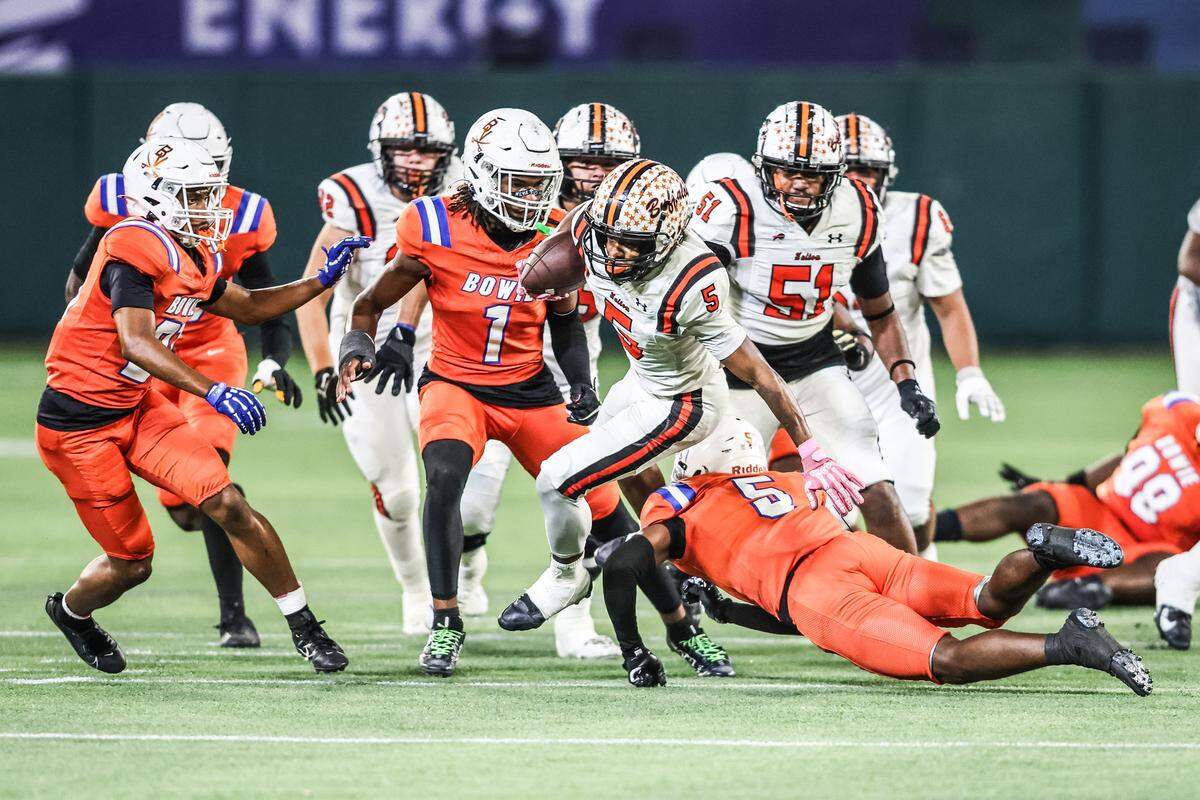 Haltom running back Vudrico Roberson (5) jumps over a defender to get a first down against Arlington Bowie on Thursday, Oct. 23, 2025, at Choctaw Stadium in Arlington.
