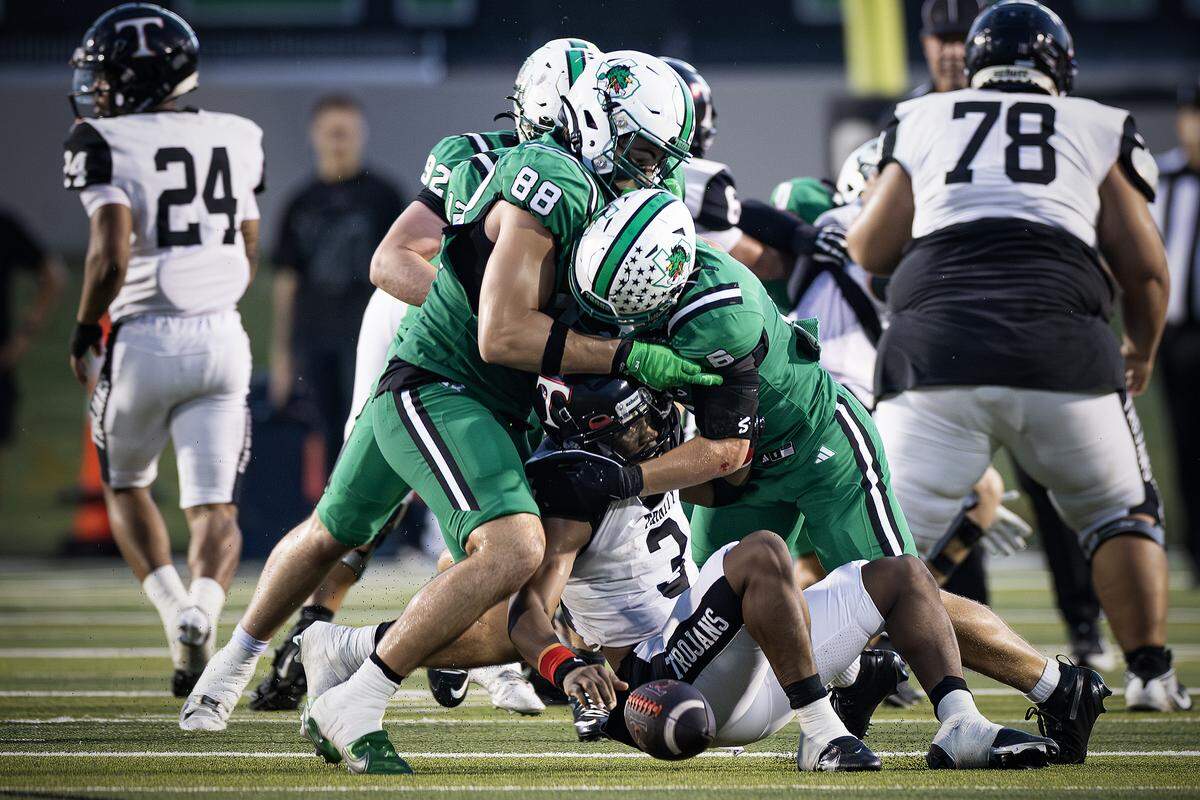 Southlake defenders Crawford Taylor (88) and Parker Harris (6) gang tackle Euless-Trinity running back Zo Palmore (3) in the first half of an high school game between Southlake Carroll and Euless-Trinity at Dragon Stadium in Southlake on Friday, Sept. 19, 2025.